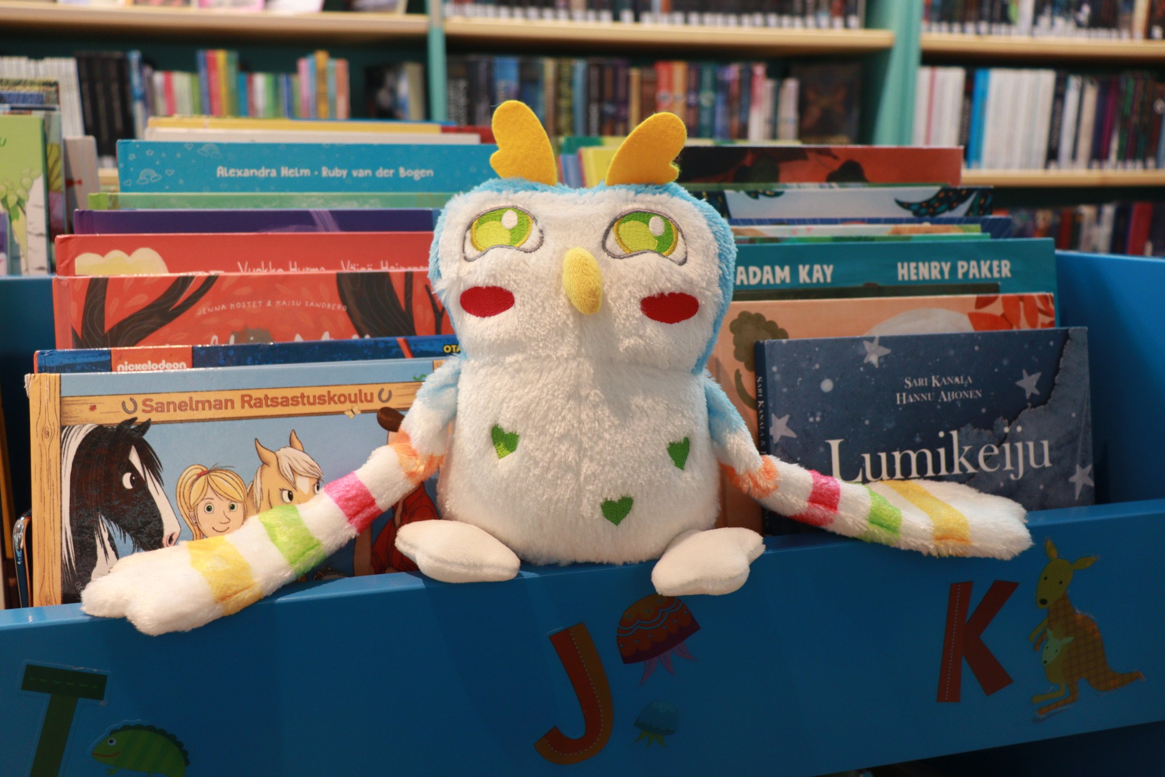 Hiihku-pehmopöllö kirjojen päällä